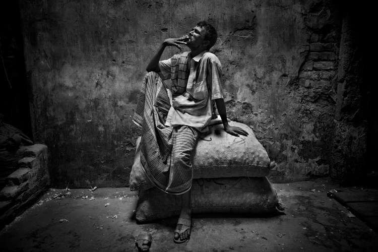 Dhaka, Bangladesz,
2010
"Pracownik bazaru wyskoczył
zapalić papierosa, siedzi na
workach z warzywami".